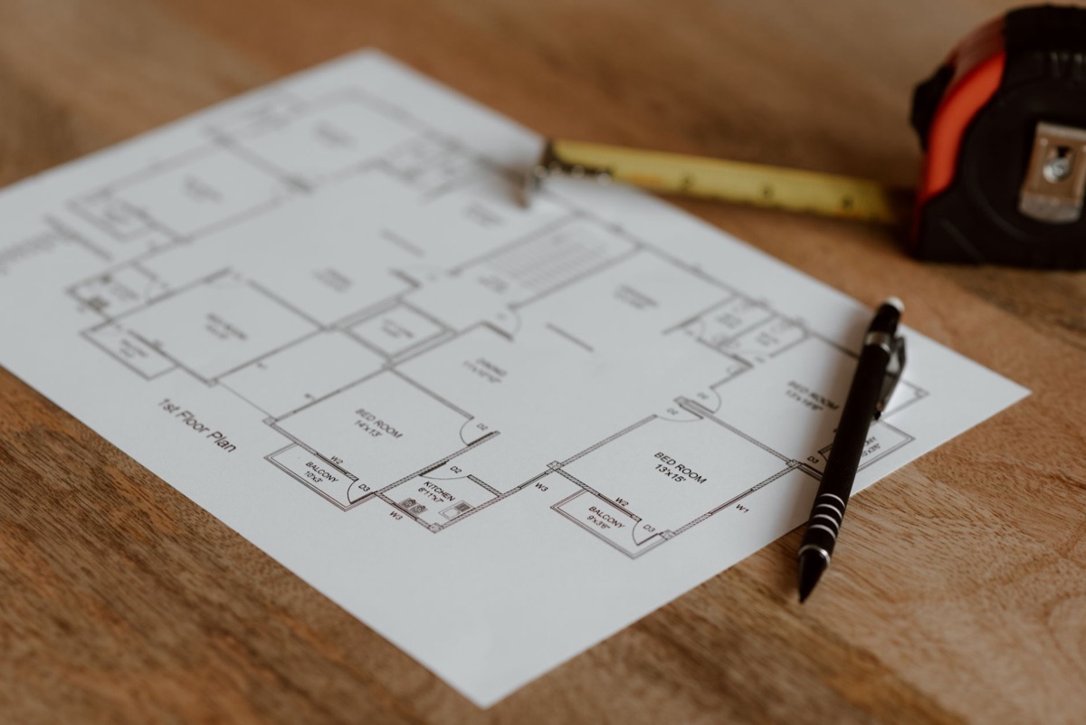 Plans d'architecte et outils de précision sur une table en bois.