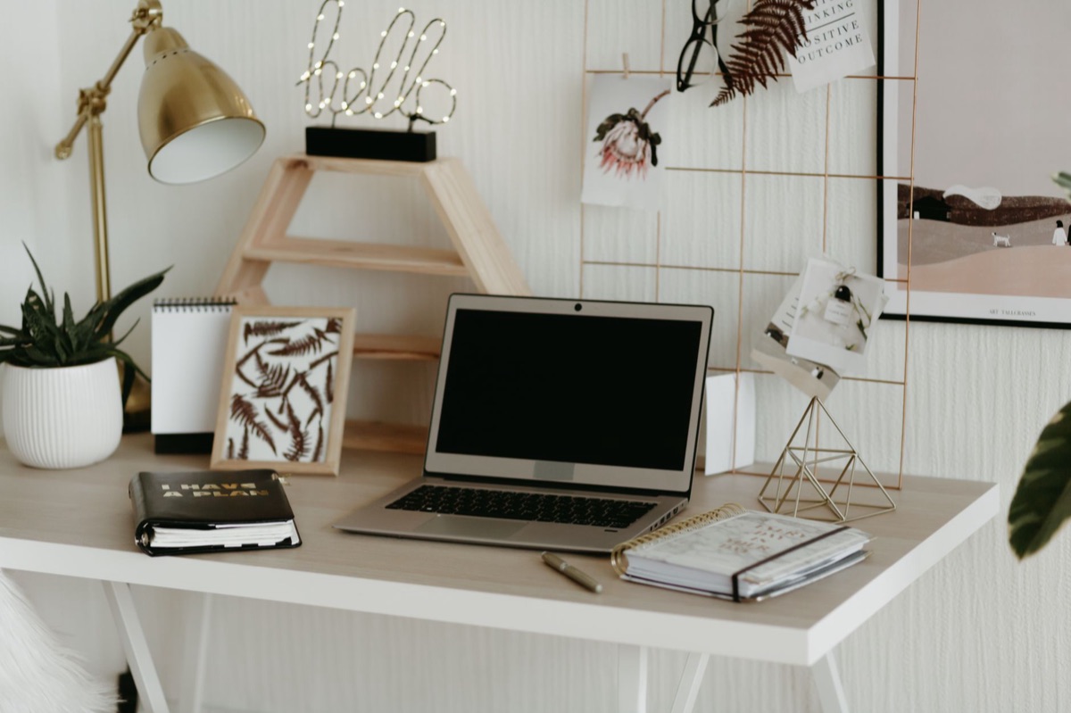 Scrivania minimalista con taccuino e lampada
