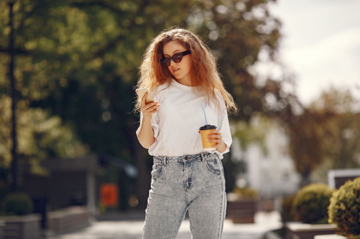 influencer con smartphone in strada romana